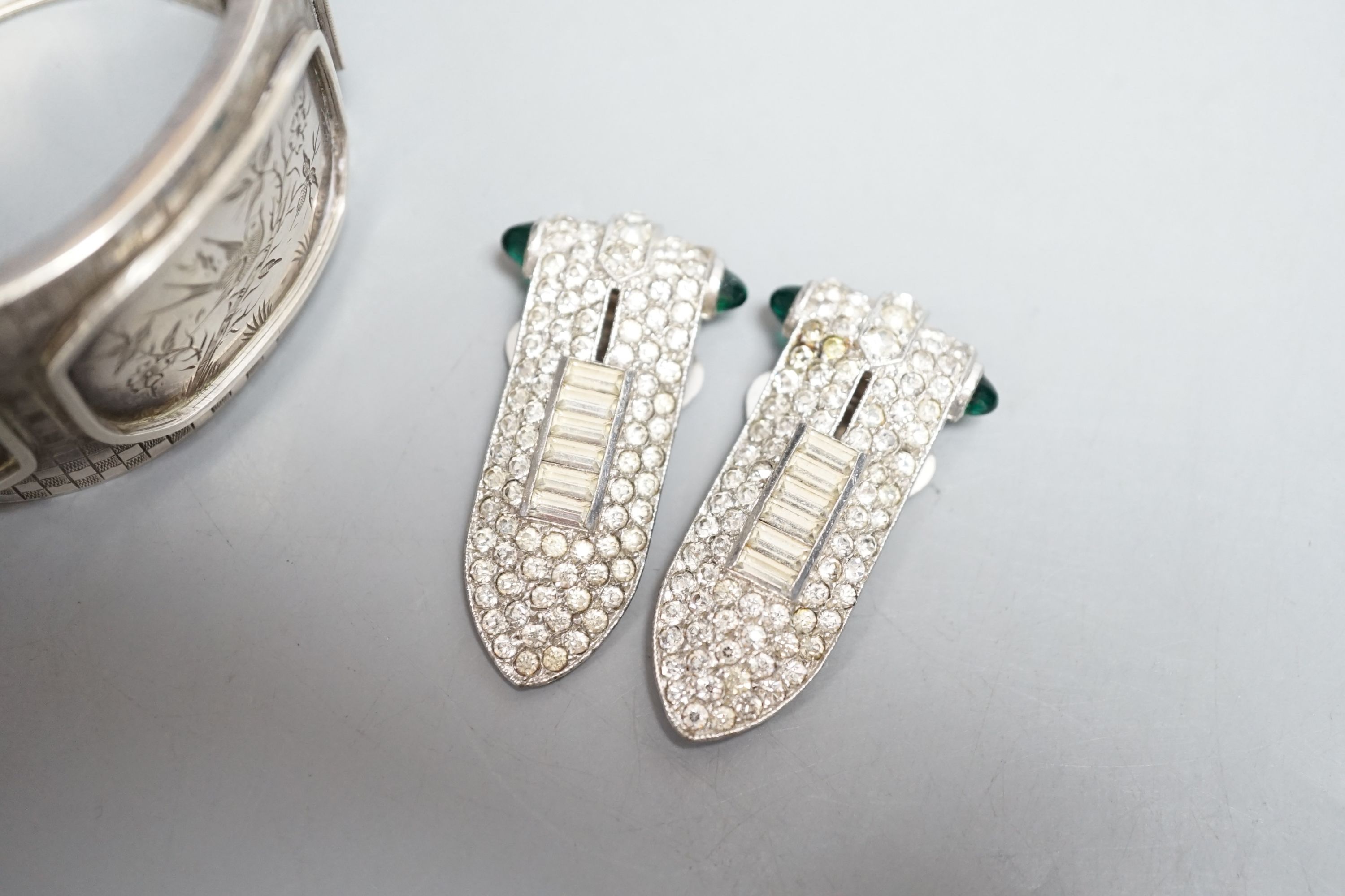 A pair of art deco paste clip earrings and a sterling bangle.